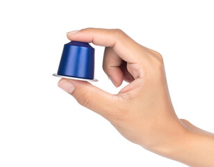 A hand holds a sleek, blue aluminum coffee capsule against a stark black backdrop, focusing on textures and color contrast