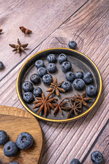 The asymmetrical arrangement of the blueberries on angled wooden boards creates a visually dynamic and contemporary composition