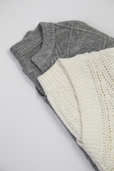 Folded Gray and White Knit Sweaters