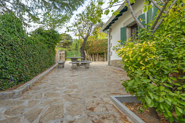 The main access path to the house features 1.5-meter-high granite walls and geometrically pruned yew hedges on either side