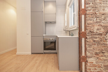 Panoramic view of a small, modern kitchen with white melamine cabinetry and a quartz countertop, visually integrated with the breakfast nook