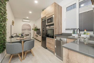 View of a kitchen with a sliding door system to visually separate the space when necessary, featuring white cabinetry and a wooden countertop