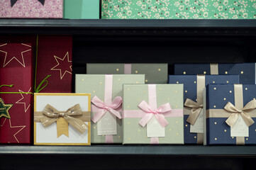 Colorful gift boxes with ribbons on store shelf