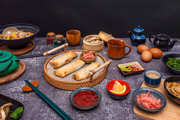 Still life with spring rolls fused with Mexican ingredients, served with avocado sauce and garnished with black sesame seeds and microgreens