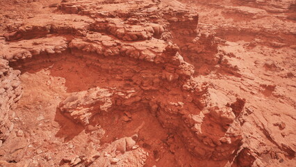 Breathtaking red rock formations stretch across the vast landscape, illuminated by the bright midday sun. Dusty terrain and unique geological patterns create a captivating view of natures artistry.