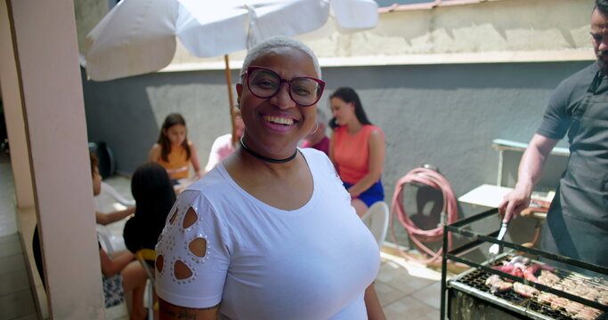 One hispanic black latina Woman smiling confidently at a backyard barbecue gathering, highlighting joy, inclusivity, and connection in a casual social setting with family and friends - Powered by Adobe