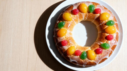 Colorful Epiphany cake with candied fruit and glaze on white plate