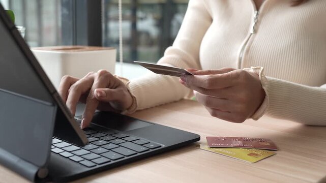 Close-up of a woman using a smartphone and holding a credit card for online shopping or payment, symbolizing digital finance and modern lifestyle.