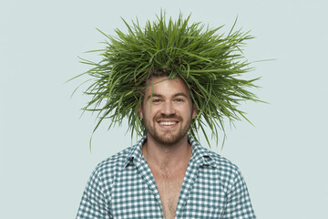 Cheerful man with green grass on his head.