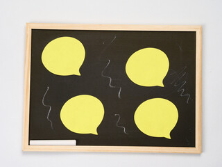 Small school blackboard with chalk and yellow blank sticky notes for personalization