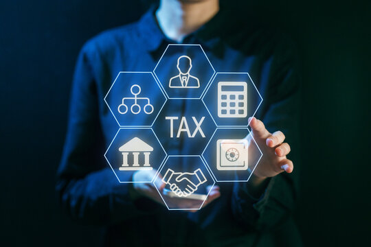 Hands working with tax symbols and icons in a dark setting to illustrate financial concepts and services - Powered by Adobe