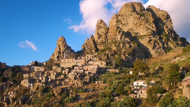 Ancient village of Pentedattilo Calabria Italy built on rocky mountain slope under sunset light with dramatic cliffs and historic stone houses symbolizing heritage and Mediterranean culture.