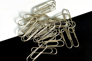 A pile of paper clips on a black and white background.