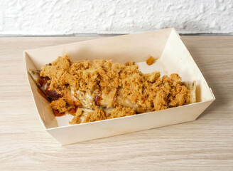 A savory crepe topped with pork floss and sweet sauce sits in a takeout box, promising a delicious and convenient lunch or snack with authentic Asian flavors.