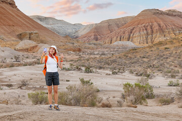 Happy hiker taking a selfie with smartphone while hiking in the desert mountains