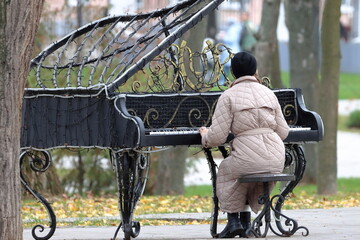 A woman at a makeshift piano in a city park