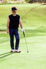 ゴルフを楽しむ日本人のミドル男性