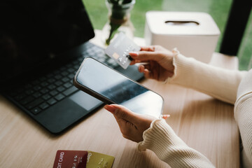Close-up of a woman using a smartphone and holding a credit card for online shopping or payment, symbolizing digital finance and modern lifestyle.