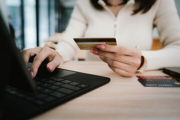 Close-up of a woman using a smartphone and holding a credit card for online shopping or payment, symbolizing digital finance and modern lifestyle.