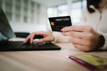 Close-up of a woman using a smartphone and holding a credit card for online shopping or payment, symbolizing digital finance and modern lifestyle.