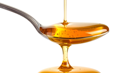 Close-up of golden liquid being poured from a spoon against a black background (1)