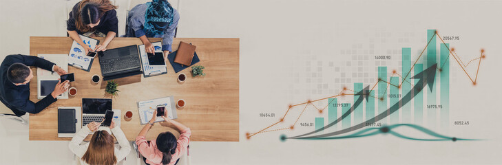 Diverse business team collaborates around table, analyzing data and charts, fostering an environment of teamwork and innovation for successful project execution and strategy development. Scalp