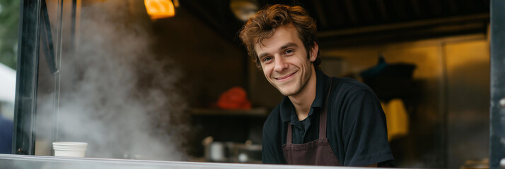 A cheerful young chef wearing an apron smiles from inside a food truck, representing passion for cooking as steam rises from delicious dishes prepared for customers.