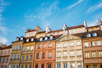 Fototapeta premium Old tiny historical houses facades and blue sunny sky in Warsaw old town square in Poland