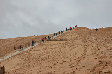 Tourists climb Dune Peel. Arcachon, Bordeaux, France