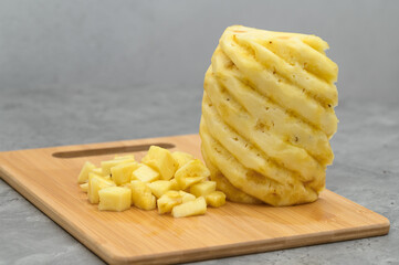 Diced pineapple lying on a cutting board, a healthy alternative to sweets