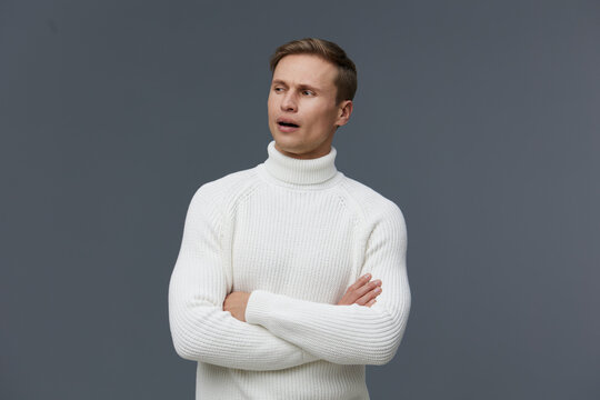 thoughtful man in white knitted sweater crossed arms look aside isolated gray background digital detox concept