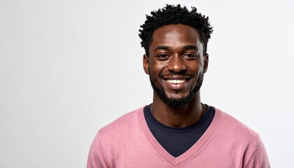 Obraz premium Portrait of a Smiling Young African American Man with Natural Hair and Pink Sweater on a Clean White Background.