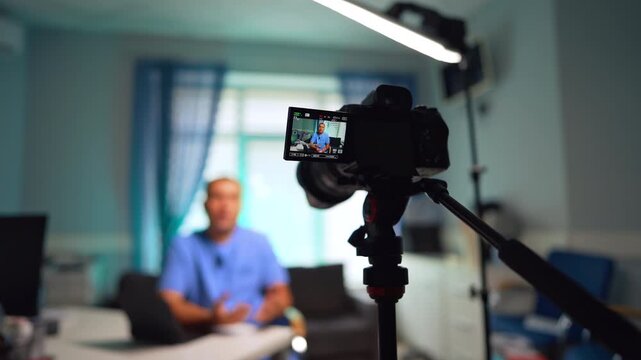 Man in blue uniform on the display of a modern camera. Medical video blog creation. Selective focus.