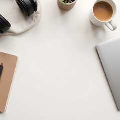 Workspace Essentials: A minimalist workspace setup featuring a laptop, notebook, pen, cup of coffee, headphones, and a small potted plant, perfect for productivity and creative work. 