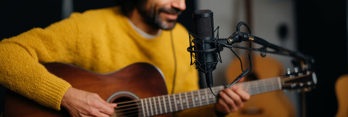 Naklejka premium A musician passionately playing guitar in a cozy studio setting, showcasing their talent while a microphone captures every note for an intimate listening experience.