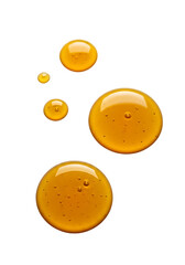 Close up of golden honey droplets glistening and reflecting light isolated on transparent background