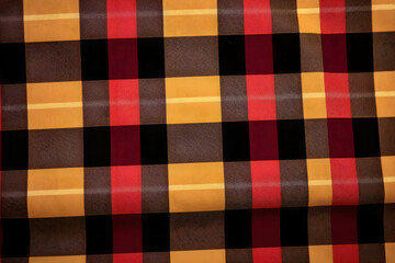 Cozy plaid blanket texture with warm yellow red and black colors