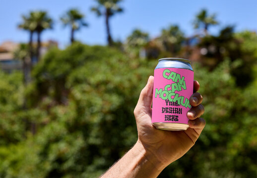 Mockup Can Design Held Outdoors With a Lush Green Background