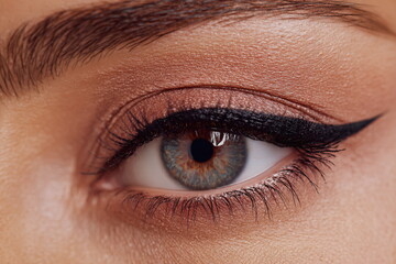 Obraz premium Beauty close up of expressive eyes with blended eyeshadow and clean brow styling. Subtle makeup effect highlighting eye shape, lashes and skin texture.