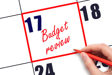 17 th day of the month.  Hand writing Budget review reminder and drawing red frame on calendar with...