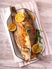 Seabass fish with lemon and rosemary on plate