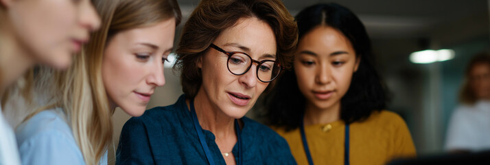 A group of women collaborate on a project, demonstrating teamwork and focus as they discuss ideas and share insights to achieve their common goal in a professional setting.