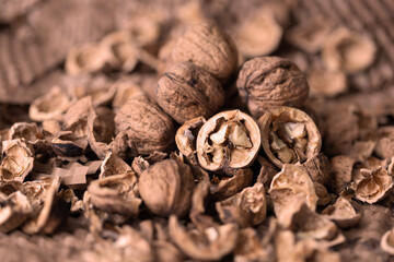 Walnuts laid out on a table covered in jute with a beautiful rustic bokeh.