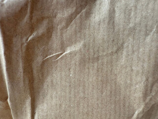 Recycling brown striped paper with a wrinkled texture. Old paper surface for background. Vintage backdrop with light reflection and slight blurring.