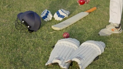 "Cricket Equipment on Field, Close-Up 4K Video, Sports Gear, Outdoor Game Footage, Bat, Ball, Pads, and Wickets Setup, Athletic Preparation Scene" - Powered by Adobe