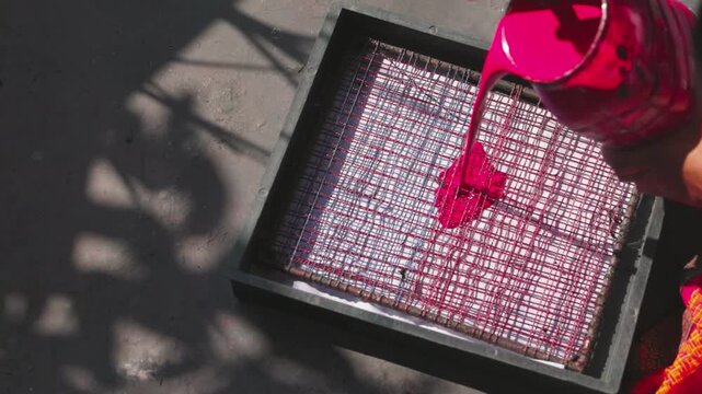 Artisan Pouring Pink Paint into Block Printing Machine, Close-Up 4K Video, Traditional Printing Process, Handcrafted Textile Artwork, Workshop Footage