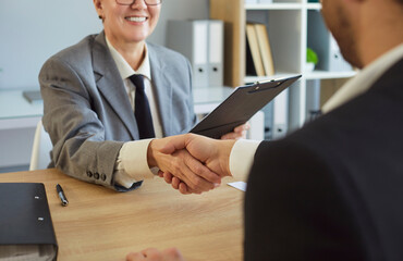 Fototapeta premium Interview handshake confirms recruiter and candidate agreement. In a modern office, staff finalize hiring after a successful meeting, confirming new employment. Strong symbol of hiring success.