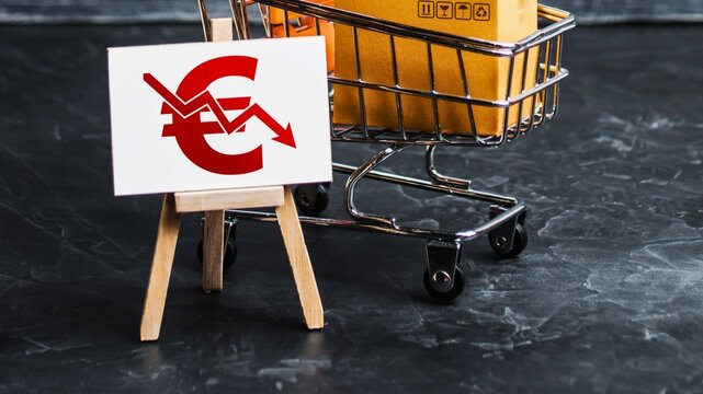 Euro symbol declining graph on easel near shopping cart