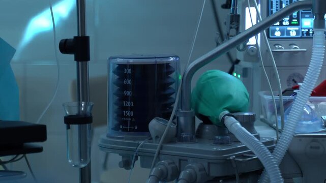 Advanced anesthesia machine with a mechanical ventilator providing artificial respiration and life support to a patient during surgery in a modern, dimly lit operating room at a hospital clinic