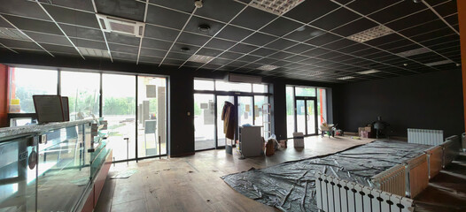 Empty cafe interior undergoing renovation with black walls and wooden flooring